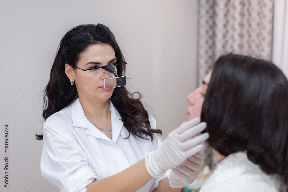 A client at a beautician's appointment, consultation, face shaping, preparation for upcoming procedures, visual examination of problem areas A client at a beautician's appointment, consultation, face shaping, preparation for upcoming procedures, visual examination of problem areas