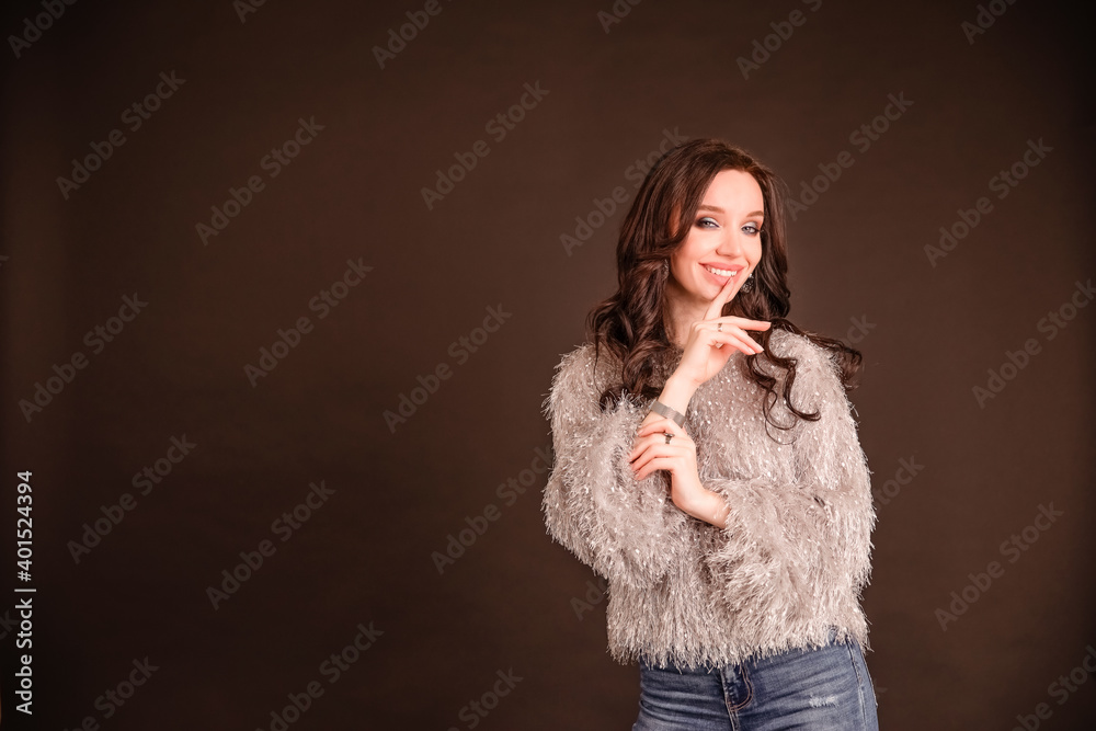 beautiful girl on a black gray background. the model thinks. girl in sweater and jeans beautiful girl on a black gray background. the model thinks. girl in sweater and jeans