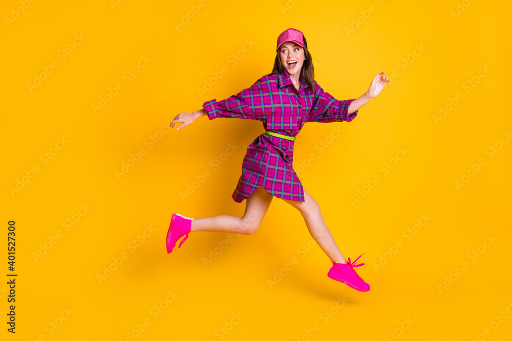 Full size profile photo of attractive lady rush looking empty space magenta headwear isolated on yellow color background