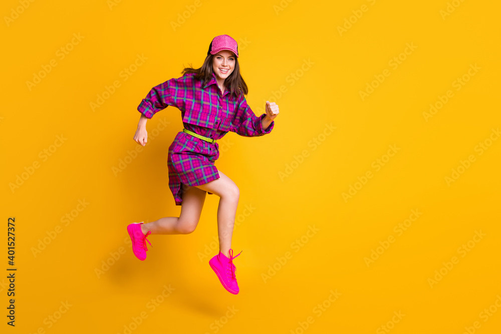 Full body portrait of attractive lady smile jump run headwear purple clothing isolated on yellow color background