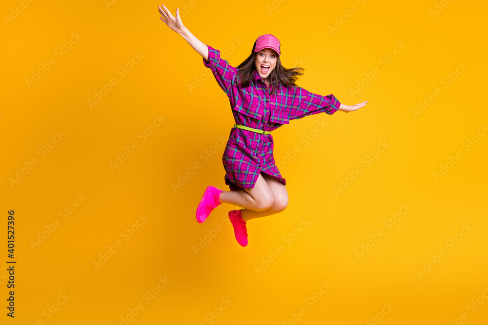 Full body portrait of cheerful girl jump arms flying success headwear isolated on yellow color background