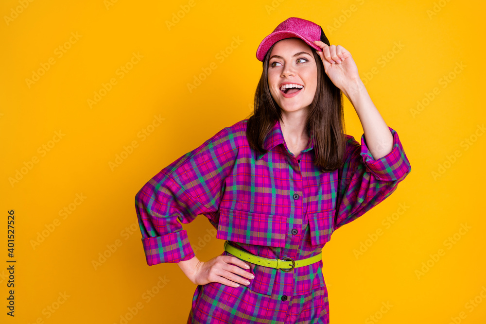 Naklejka premium Photo of attractive lady put arm on waist looking empty space headwear isolated on vivid yellow color background