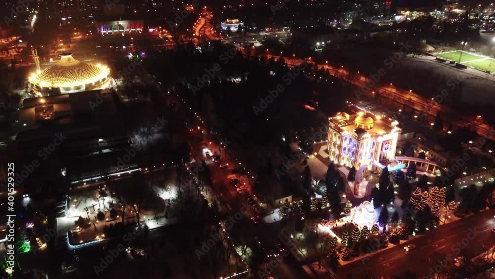 The city is decorated for Christmas and new year. Buildings, garlands, Christmas trees, fences and the square glow with different lights. People relax, enjoy the winter and holiday. View from a drone The city is decorated for Christmas and new year. Buildings, garlands, Christmas trees, fences and the square glow with different lights. People relax, enjoy the winter and holiday. View from a drone
