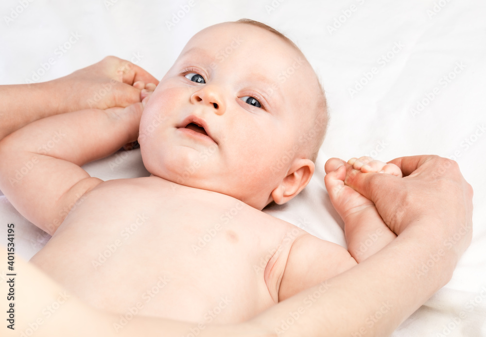 FIve month baby boy receiving massage therapy in pediatric clinic. Manual therapist manipulates childs's arms FIve month baby boy receiving massage therapy in pediatric clinic. Manual therapist manipulates childs's arms