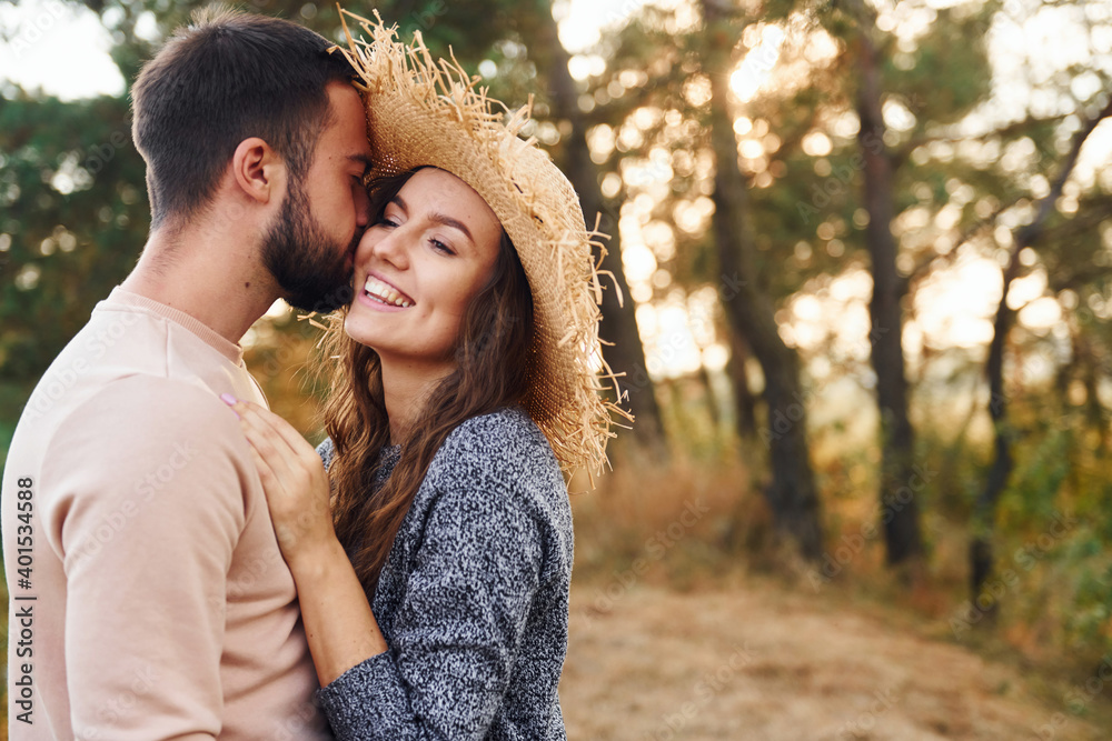 Standing and hugging. Cheerful lovely young couple having a rest outdoors together Standing and hugging. Cheerful lovely young couple having a rest outdoors together
