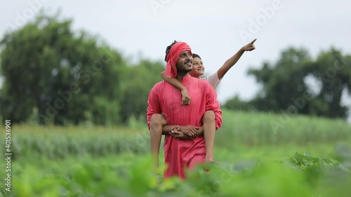 Indian farmer playing with his child at green field