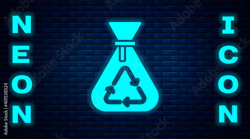 Glowing neon Garbage bag with recycle symbol icon isolated on brick wall background. Trash can icon. Recycle basket sign. Vector.