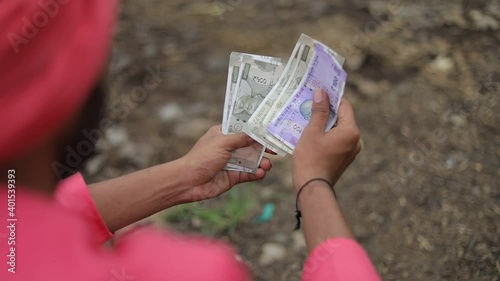 Young indian farmer counting and showing money