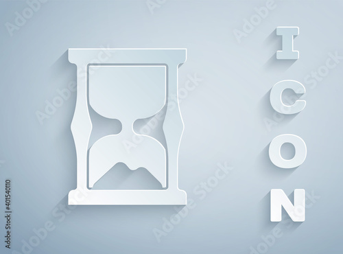Paper cut Old hourglass with flowing sand icon isolated on grey background. Sand clock sign. Business and time management concept. Paper art style. Vector.
