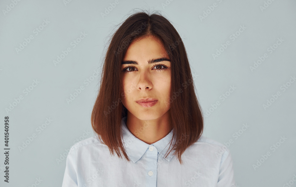 Young modern woman in white shirt standing inside of the studio