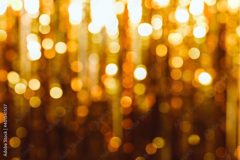 Festive tinsel of Golden color. The Golden rain is blurred and unfocused as the background and texture.