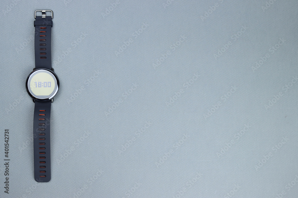 Black smart watch with round dial on gray background. Space for text Black smart watch with round dial on gray background. Space for text