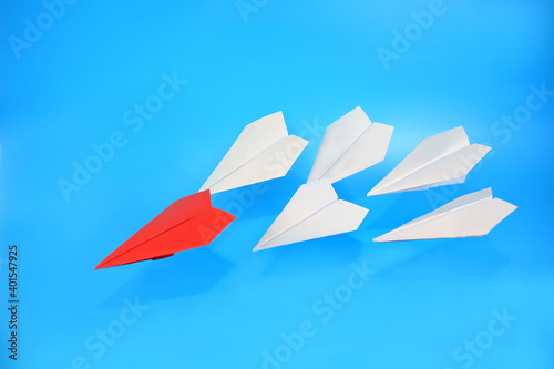 red paper plane lead the group, the first