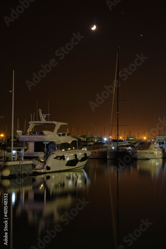 port in crescent moon night with reflections in the sea