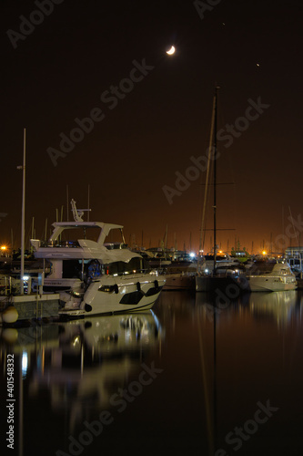 port in crescent moon night with reflections in the sea photo