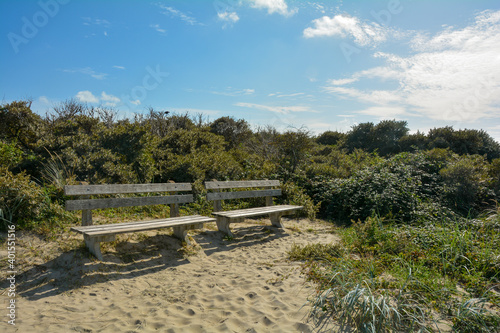 There are two benches in the sand dunes