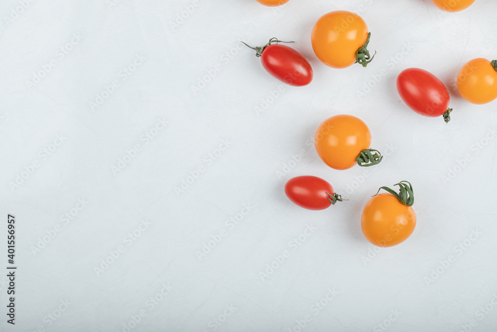 Fresh organic red and yellow tomatoes on white background