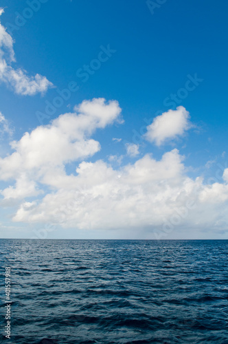 Deep ocean view with waves and white clouds. Relaxing seascape  endless sea  tropical waters background. Blue seas and skies separated by a far away horizon. Caribbean lifestyle themes