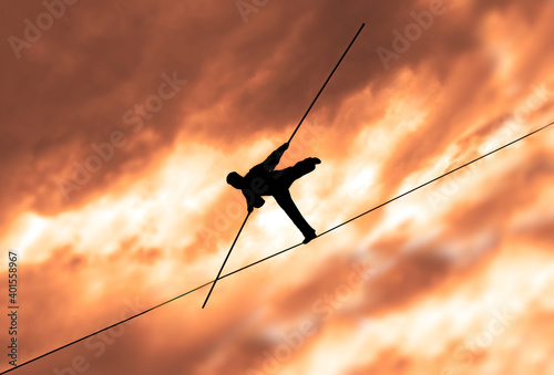 фотографія Wandering tightrope walker playing on yellow sky background