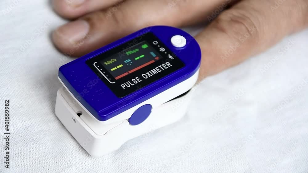A man put on a pulse oximeter on his finger and checks his heart rate
