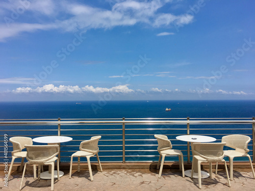 Terrace with a view on sea. Umbrellas and lounge chair in a sunlight.