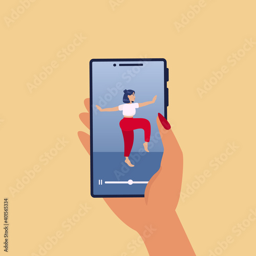 Stay active at home concept. Online coach banner - female personal fitness trainer coming out of smartphone screen holding. Female hand holding smartphone. Training via Internet video call. 