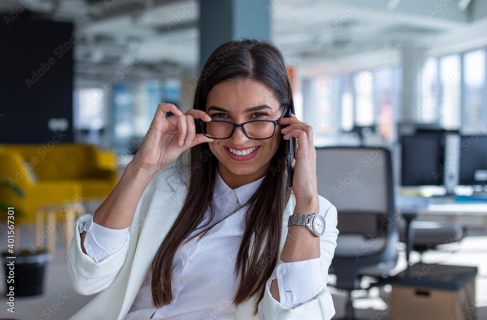 Portrait of a young businesswoman with glasses sitting in the office. Portrait of a young businesswoman with glasses sitting in the office.