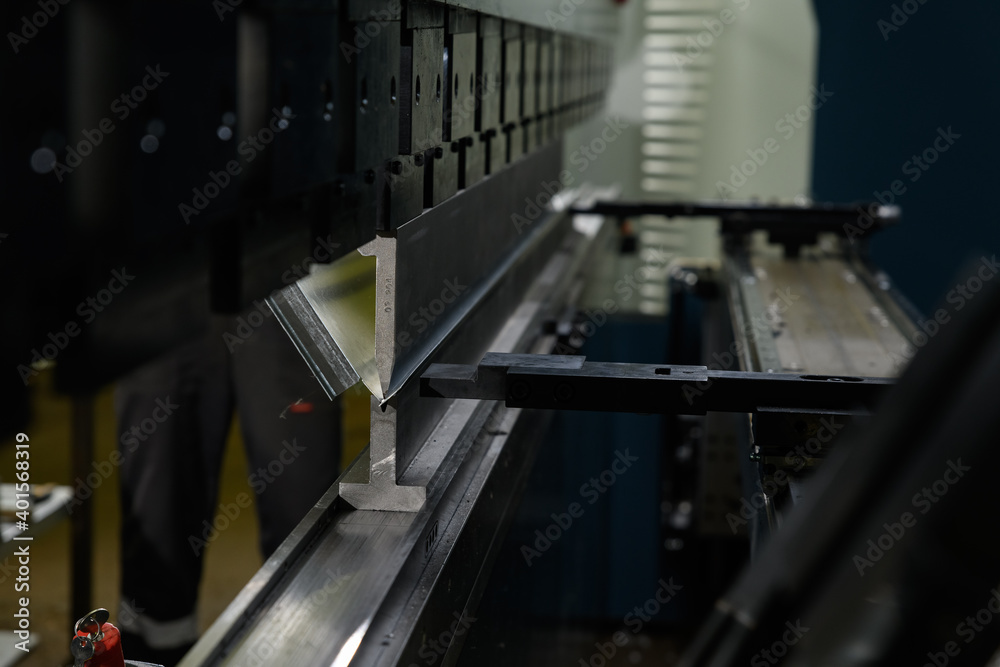 worker operating metal press machine at workshop. worker operating metal press machine at workshop.