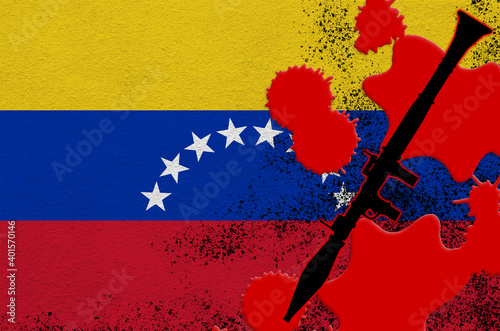 Venezuela flag and black RPG-7 rocket-propelled grenade launcher in red blood. Concept for terror attack or military operations with lethal outcome photo