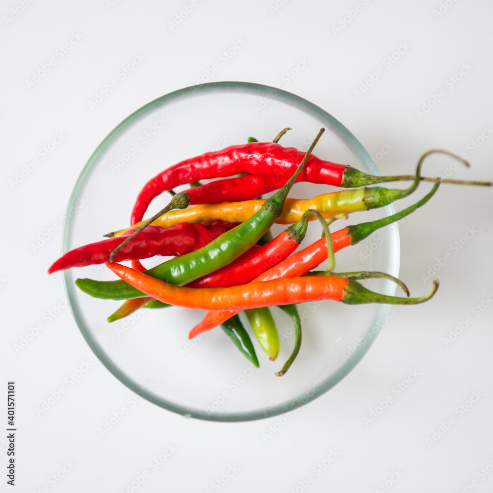 Chili peppers in a transparent bowl on a white background