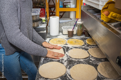 A girl making doner buns in a local pizza and gyros restaurant
