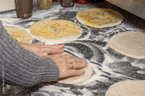 A girl making doner buns in a local pizza and gyros restaurant