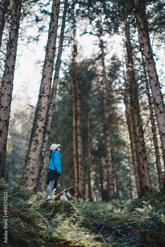 Frau mit Hund genießt Aussicht und Ruhe im Wald