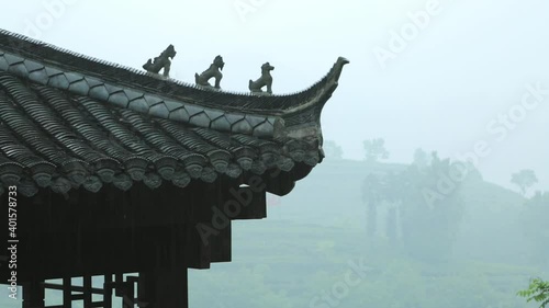 Carved details on the eaves of an ancient Chinese building roof, a roof of an ancient building in the rain