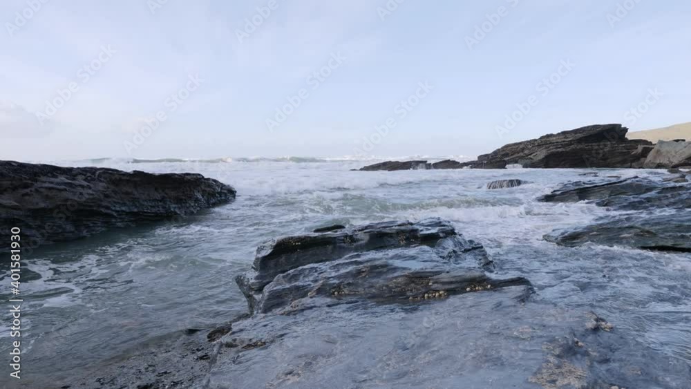 A large wave rushes toward the camera though stunning coastline. A large wave rushes toward the camera though stunning coastline.