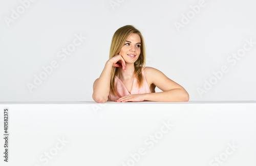Shopping concept. Portrait of girl. Goods for female. Femininity and tenderness. Lady lean copy space surface. Beauty shop. Adorable woman stand behind banner. Advertisement marketing and promotion