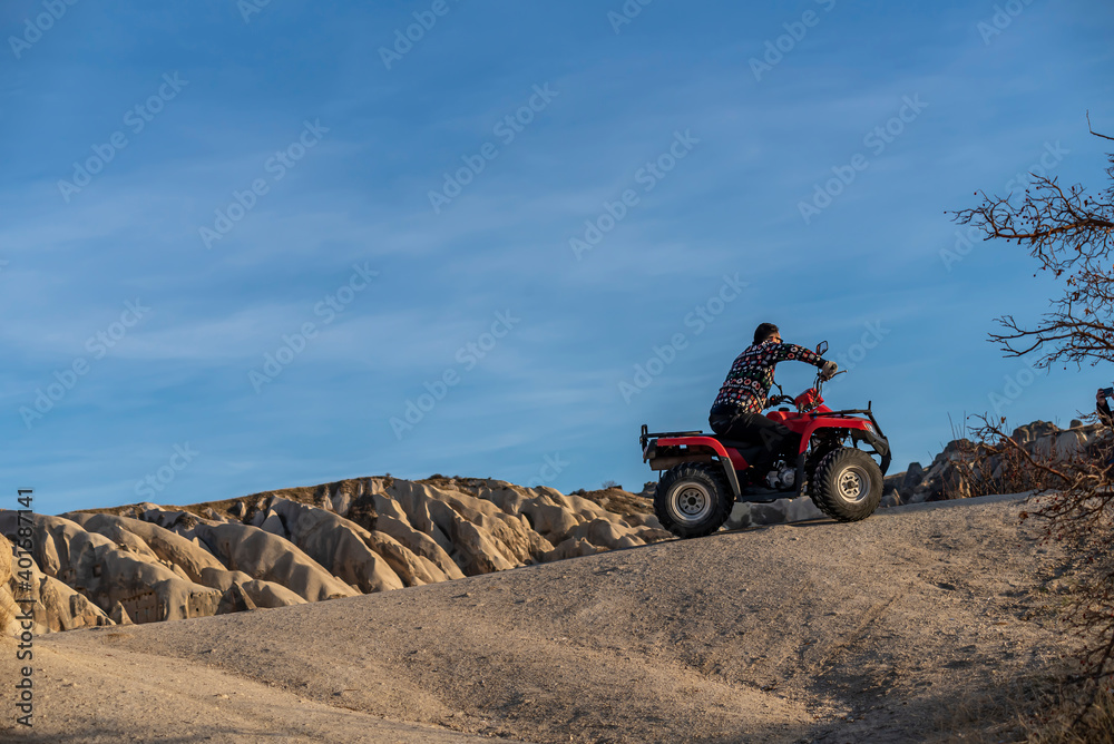 Obraz premium Tourists on safari in Cappadocia with ATV vehicles with views of beautiful fairy chimneys and vineyards
