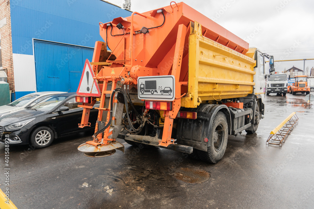 Fototapeta premium The machine that sprinkles salt on the road in winte