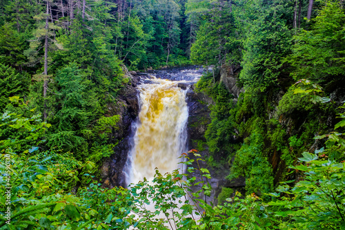 Moxie Falls plunging about 90 feet to a pool below, is one of the largest waterfalls in New England. Located amidst lush green woods in Maine, USA, it is very scenic and is a popular tourist spot.