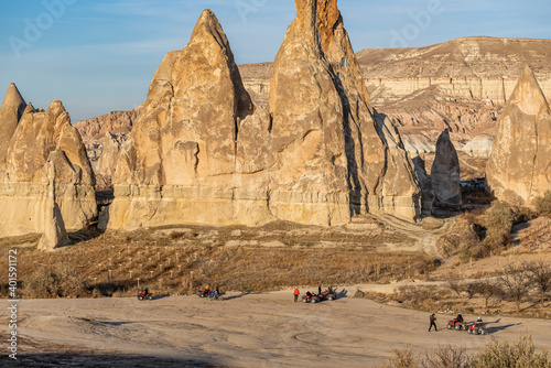 Tourists on safari in Cappadocia with ATV vehicles with views of beautiful fairy chimneys and vineyards