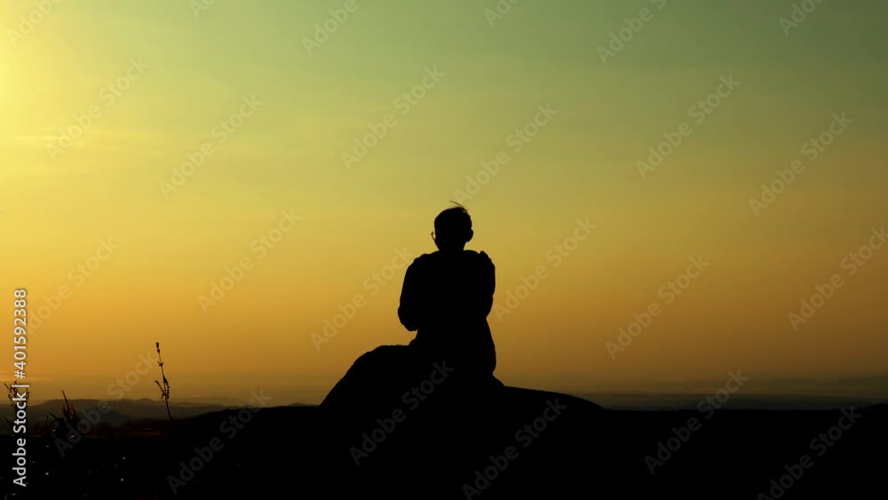 Man sitting in silhouette looking at the clear sky Man sitting in silhouette looking at the clear sky