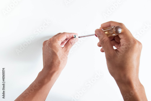 Tableau sur toile Top angle of young man right handed, holding philip screwdriver and screw on whi