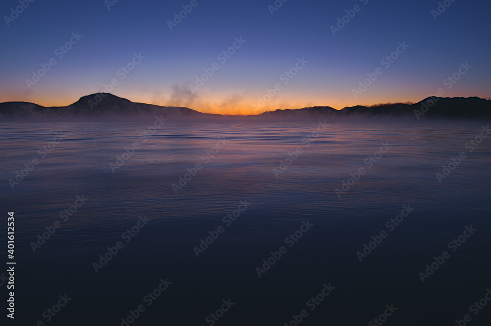 うっすらと靄の漂う夜明けの湖。
