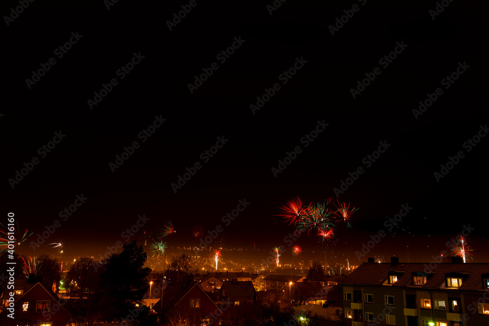 Obraz premium Fireworks on a dark sky over city skyline