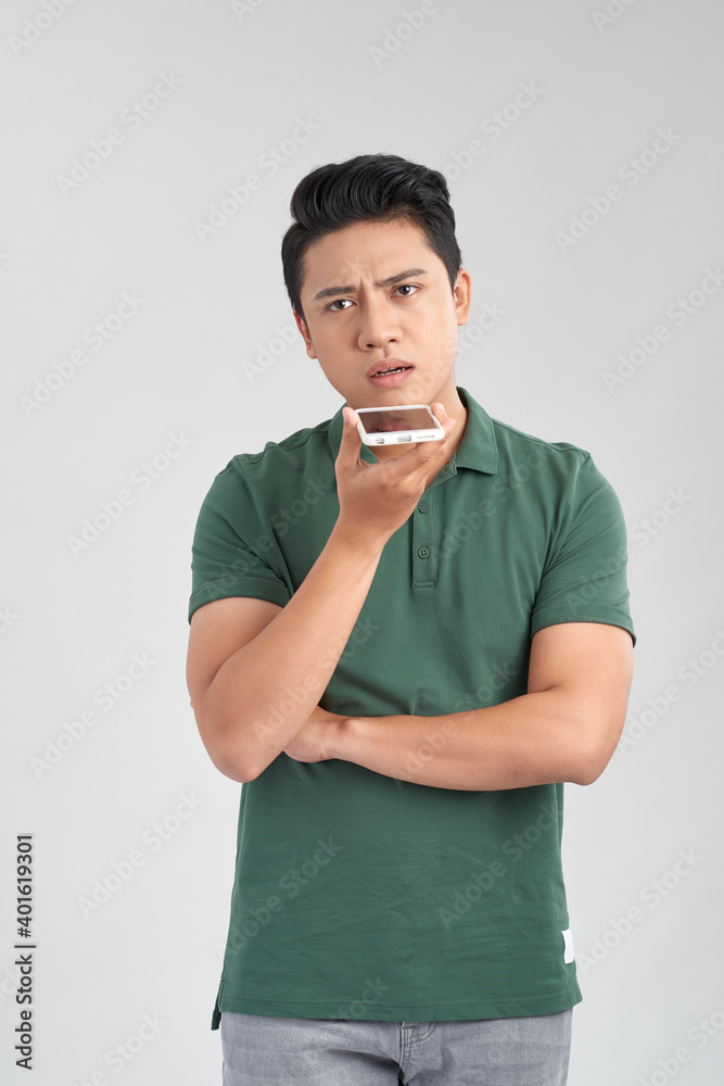 You will have problems man! Portrait of angry confused aggressive in bad mood guy talking in the loudspeaker of his smartphone, isolated on white background You will have problems man! Portrait of angry confused aggressive in bad mood guy talking in the loudspeaker of his smartphone, isolated on white background