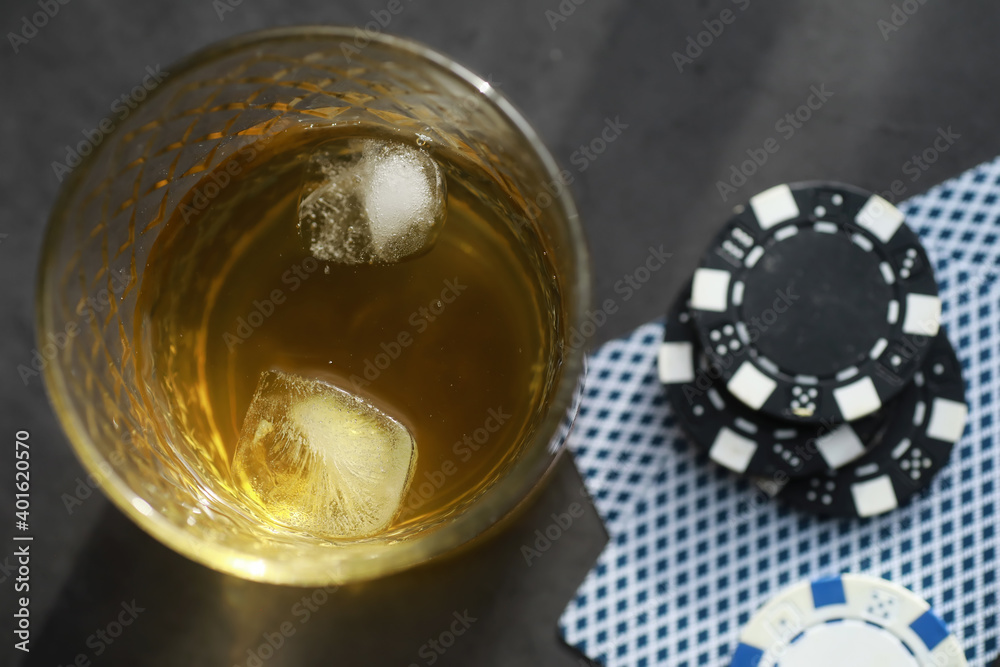 Gambling Card games for money. Texas Hold'em Poker. Cards in hand, playing chips, a deck of cards of alcohol in a glass.