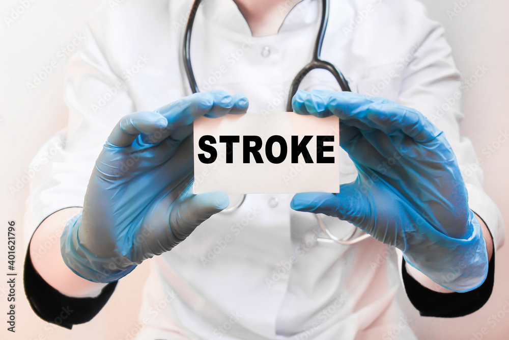 The doctor's blue - gloved hands show the word STROKE - . a gloved hand on a white background. Medical concept. the medicine The doctor's blue - gloved hands show the word STROKE - . a gloved hand on a white background. Medical concept. the medicine