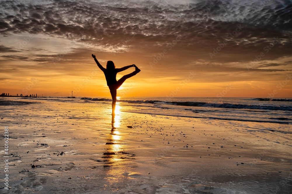 yoga at sunset on the beach. woman is doing yoga and enjoying life on the sea
