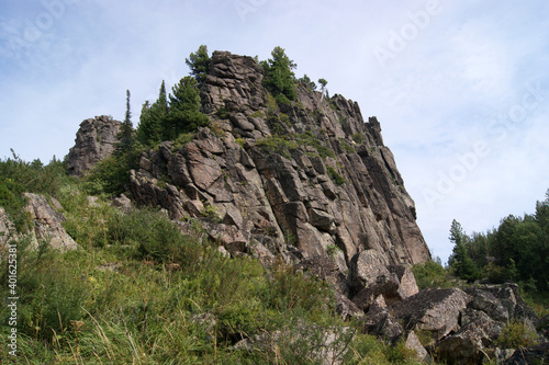 Rocky ledges of the mountain Babyrgan against the blue sky in Altai in Russia