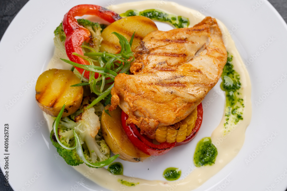 Grilled turkey fillet with vegetables on a white plate for the restaurant menu. The view from the top.